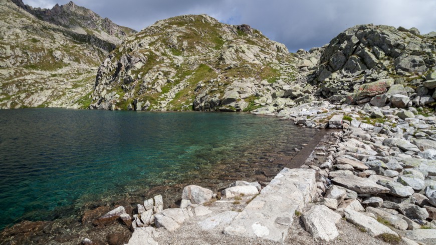 Rocks and lake with mountains on the background